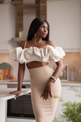 Classy black girl in a beautiful outfit standing in a luxury kitchen