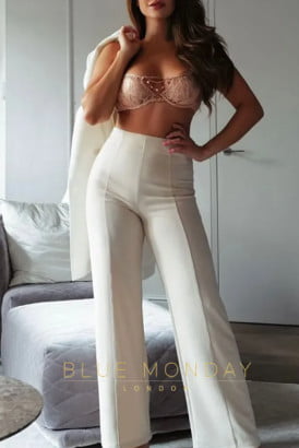 Stylish brunette in white trousers and a pink bra