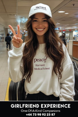 Very cute brunette wearing a baseball cap and showing the V sign