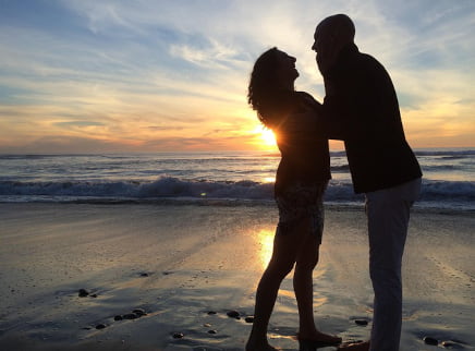 The rise of girlfriend experience bookins in the UK A boyfriend and girlfriend on a beach at sundown